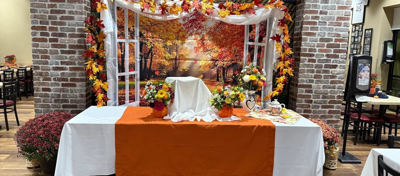 Paisan's banquet room arranged for a celebration of life, with flowers and a memorial table
