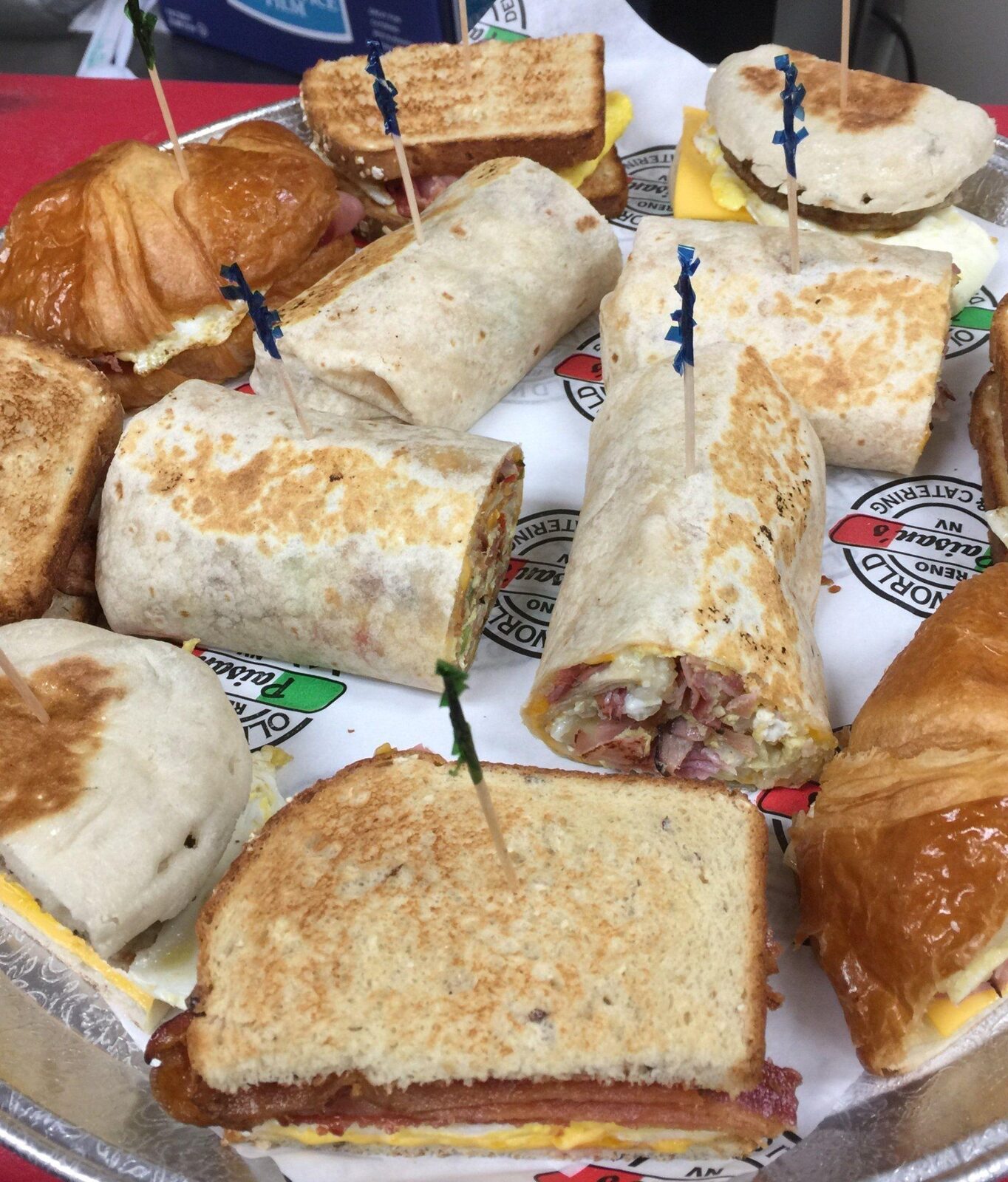 A tray of breakfast sandwiches and burritos